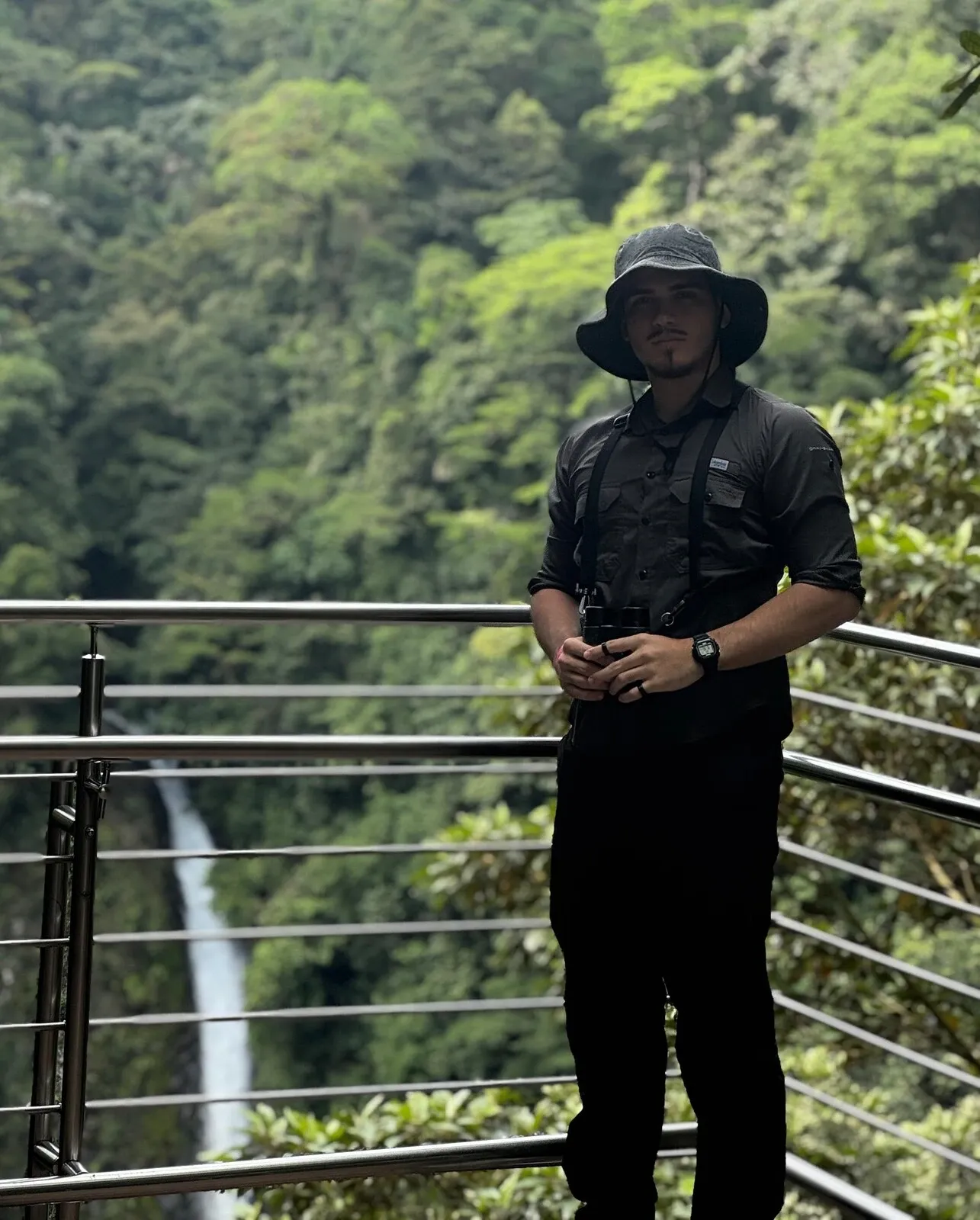Bernald Ramirez en un mirador frente a una catarata, rodeado de bosque
