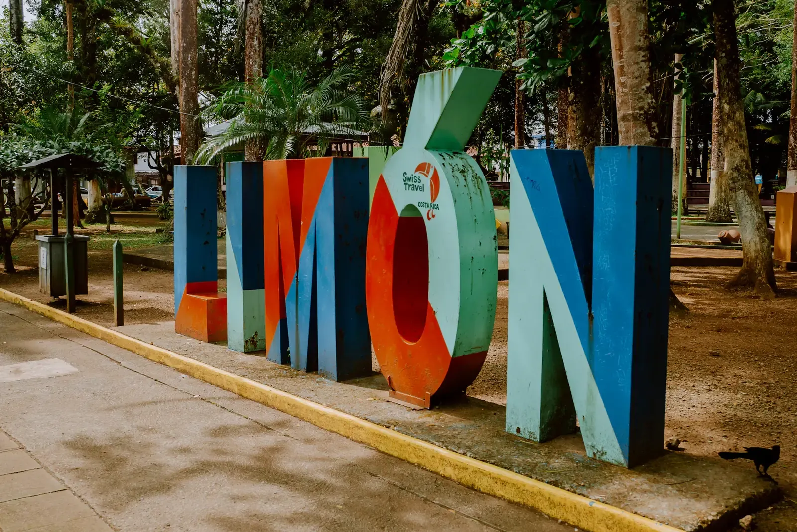 Letras de colores que forman la palabra Limón en un parque con árboles