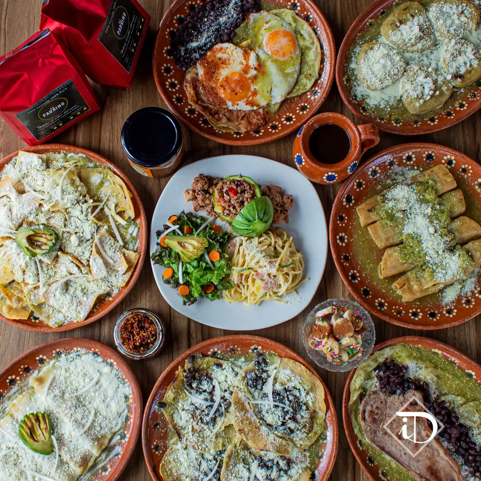 Mesa servida con muchos platos de comida casera: huevos, frijoles, aguacate y ensaladas